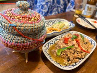 カオニャオ（もち米）が入った籠と美味しそうなタイ料理のガパオ