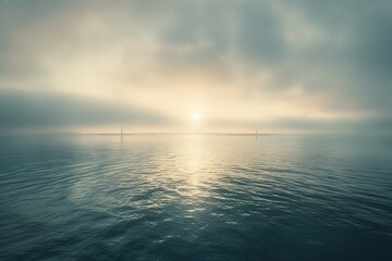 Sun rising over still water with a distant bridge shrouded in mist Serene view