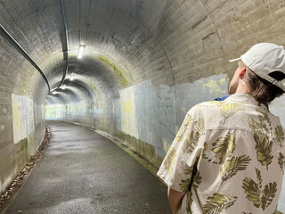 トンネルの出口を見る男性