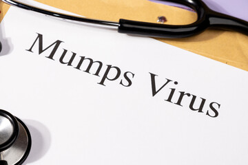 A Paper with “Mumps Virus” Title in Clipboard Set on the Desk with Stethoscope – Salivary...