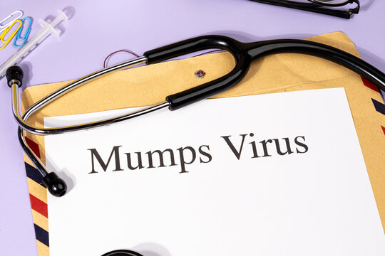 A Paper with &ldquo;Mumps Virus&rdquo; Title in Clipboard Set on the Desk with Stethoscope &ndash; Salivary Gland Infection Concept