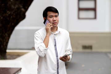 Businessman in casual clothes talking on the phone walking outdoors