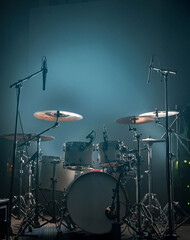 Drum set with microphones on stage with neutral background