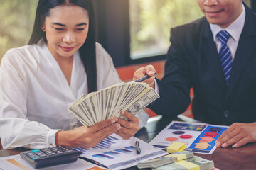 Businesswoman holding money banknotes and making decision for business investment. Selected focus