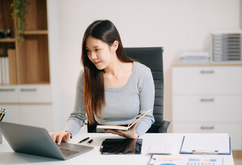 Confident Asian woman with a smile standing holding notepad and tablet