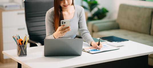 Confident Asian woman with a smile standing holding notepad and tablet