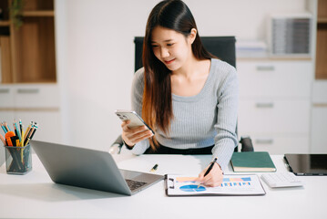 Confident Asian woman with a smile standing holding notepad and tablet