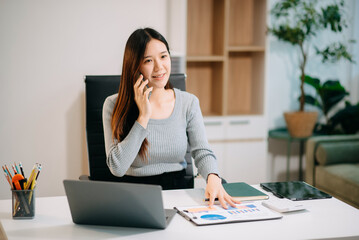 Confident Asian woman with a smile standing holding notepad and tablet