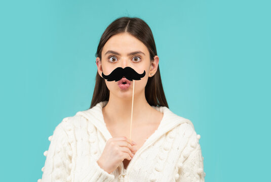 Girl, moustache and happy with prop. Comic woman portrait. Funny face with moustache on stick. Funny woman holding paper moustache party stick. Girl holding funny mustache.
