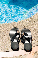 Striped flip flops by the pool on a sunny summer day