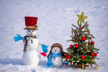 Funny snowman in snowy landscape. Snowman in winter holiday. Decorated snowman. Greeting card for...