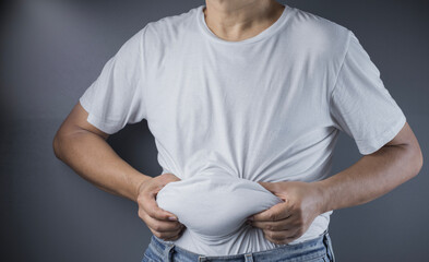 overweight or obese man shows fat deposits in the abdomen. healthcare, medicine concept. he is...
