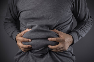 overweight or obese man shows fat deposits in the abdomen. healthcare, medicine concept. he is...