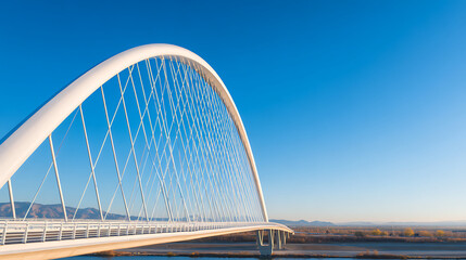 Obraz premium p3685236 481 A modern curved arch bridge showcasing a sleek steel structure over a highway beneath a clear blue sky during daytime 17953687 1