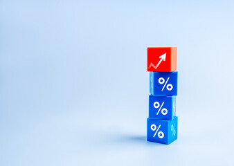 Business growth process and economic, grow marketing, inflation, interest rates and tax concepts. Rise arrow on red, stack on blue cube blocks with percentage icon, plain background with copy space.