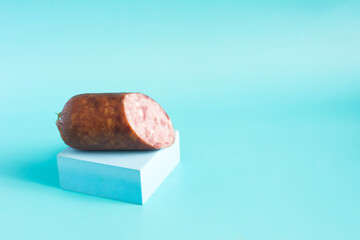 A piece of delicious homemade sausage in a package in close-up on a light background