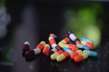 Illustration of various capsules used for treatment against a dark background