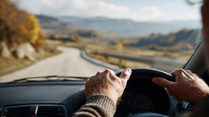 Man driving car on winding road with focus on his hands gripping steering wheel in scenic countryside setting
