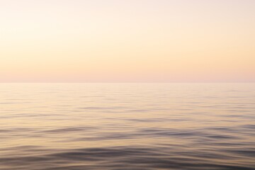 Obraz premium Tranquil seascape with soft pastel light at sunset creating a peaceful natural background over calm ocean horizon in a minimal landscape scene.
