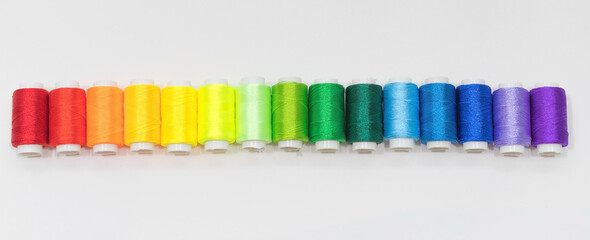 Rainbow Embroidery Threads in a Row on Light Background Flat Lay