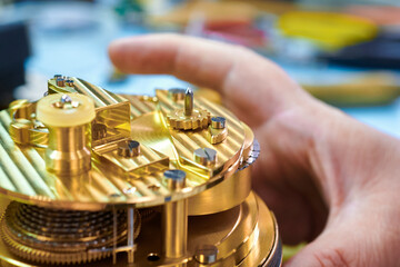 Intricate craftsmanship shines as hands delicately repair an exquisite chronometer in a workshop...
