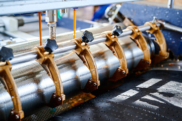 Intricate design of glue rollers in action at a cardboard manufacturing plant showcasing a blend of...
