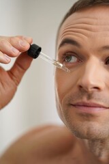 Man Applying Serum with Dropper for Skin Care