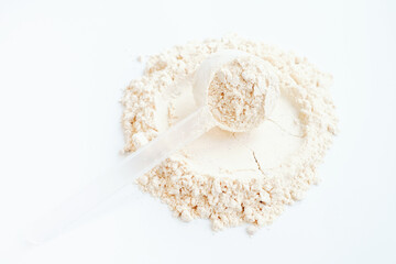Protein powder in scoop on white background, top view.