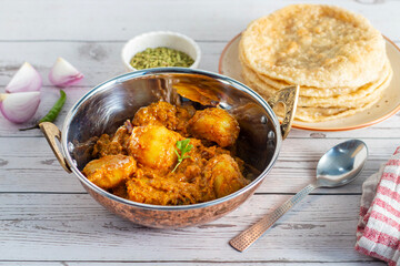 Dum aloo is a rich, spiced potato curry slow-cooked in a flavorful gravy, traditionally served hot with soft, fluffy pooris for a satisfying meal.
