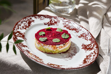 Herring under beetroot salad, bright daylight, elegant overhead ceramic plate composition