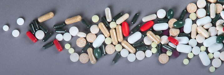 Heap of pills on grey background