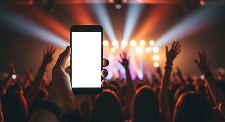A hand holds a smartphone with a blank white screen amidst a blurred, energetic concert crowd and vibrant stage lights