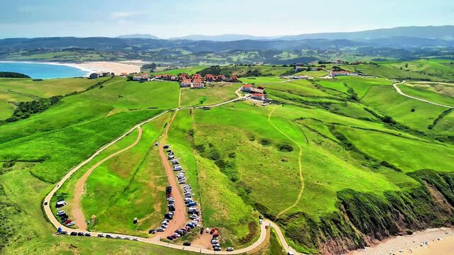 A truly stunning aerial shot beautifully capturing the lush green hills beside a serene beach with gentle waves