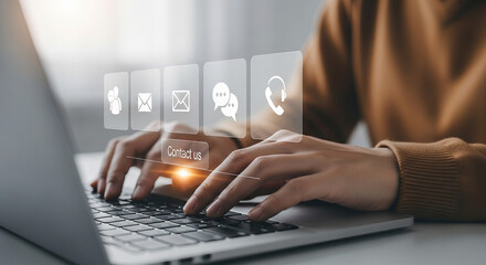 Person using a laptop with contact us icons for communication and support