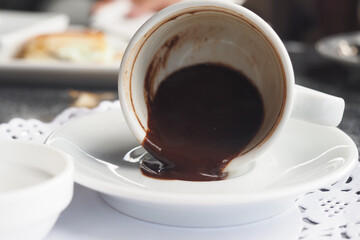 Empty coffee cup on a white saucer with brown residue