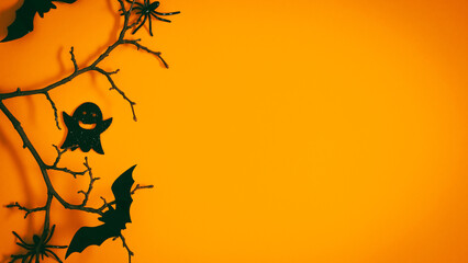 Halloween decorations, spiders, web, ghost and bat on orange background. Halloween party concept.