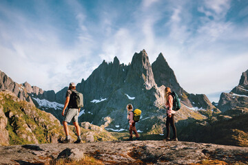 Family travel hike in Norway - active people group parents with child explore Lofoten islands...