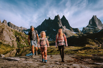 Family hiking in Norway parents travel with kid in Lofoten islands active summer vacations tour...
