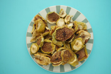 Dried figs on a plate against a blue background