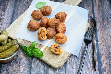 Mini cheese  burger balls.  Ball shaped snack with meat, pickled cucumbers and tomato on wooden background
