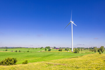 Cultivated landscape with a high wind turbine a sunny summer day in the countryside