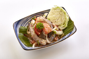 Fresh seafood salad with shrimp, salmon, and vegetables served in decorative bowl with cabbage garnish, offering vibrant and appetizing presentation