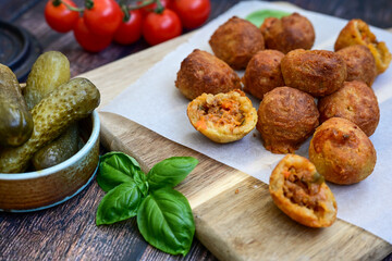 Mini cheese  burger balls.  Ball shaped snack with meat, pickled cucumbers and tomato on wooden...