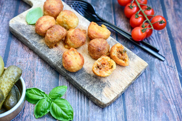 Mini cheese  burger balls.  Ball shaped snack with meat, pickled cucumbers and tomato on wooden...