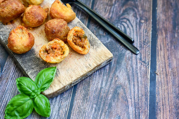 Mini cheese  burger balls.  Ball shaped snack with meat, pickled cucumbers and tomato on wooden...