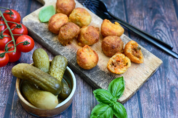Mini cheese  burger balls.  Ball shaped snack with meat, pickled cucumbers and tomato on wooden...