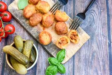 Mini cheese  burger balls.  Ball shaped snack with meat, pickled cucumbers and tomato on wooden background