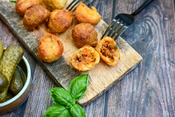 Mini cheese  burger balls.  Ball shaped snack with meat, pickled cucumbers and tomato on wooden background