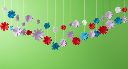 A festive garland of colorful paper flowers hanging against a bright green background