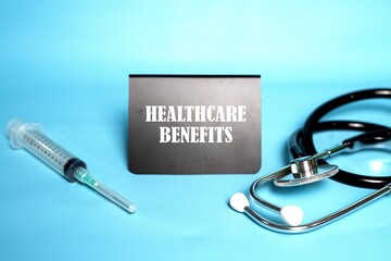 HEALTHCARE BENEFITS words on a mini whiteboard. Medical and health concepts.